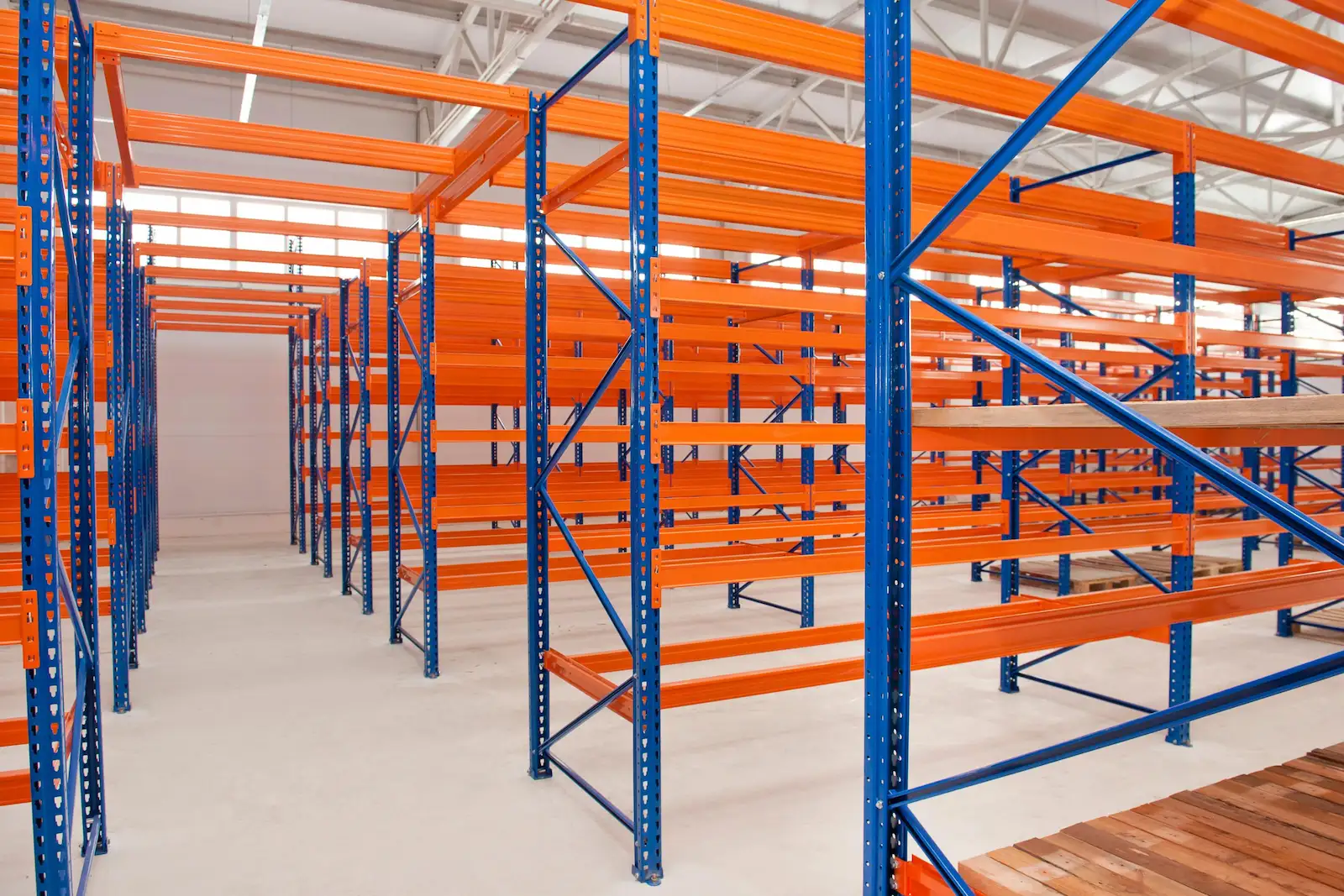 Orange and blue shelving and racking in an empty warehouse.