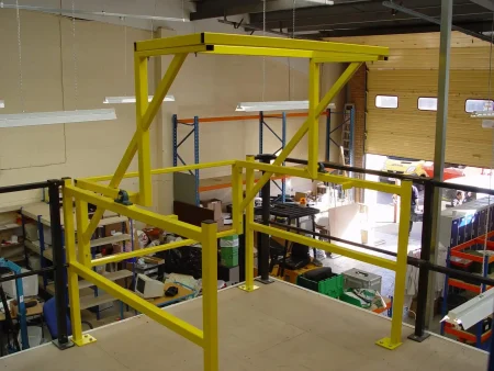A yellow mezzanine safety pallet gate in a warehouse.