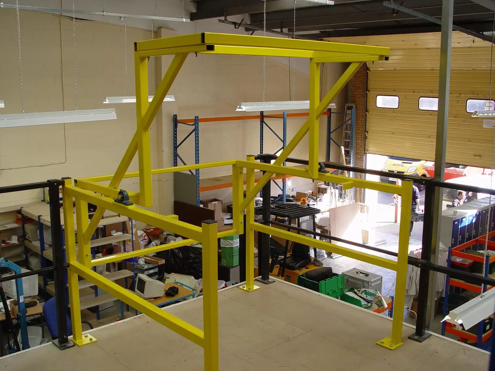 A yellow mezzanine safety pallet gate in a warehouse.
