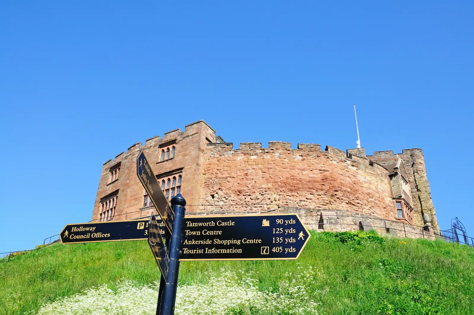A ground floor view of Tamworth Castle on a sunny day. There are no clouds in the sky.